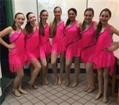 Seven girls standing in dance costumes