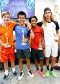 Four older boys holding trophies after a junior tennis tournament.